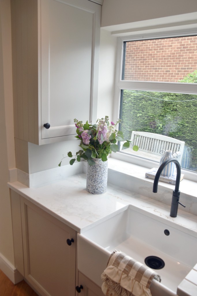 Off-white shaker cabinetry with farmhouse sink