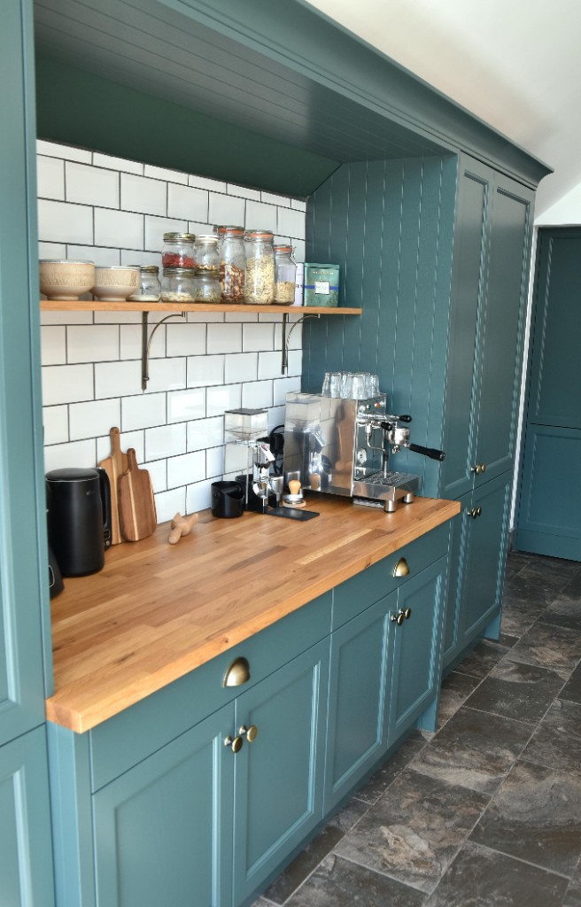 Deep teal coffee nook with oak worktop and white subway tile
