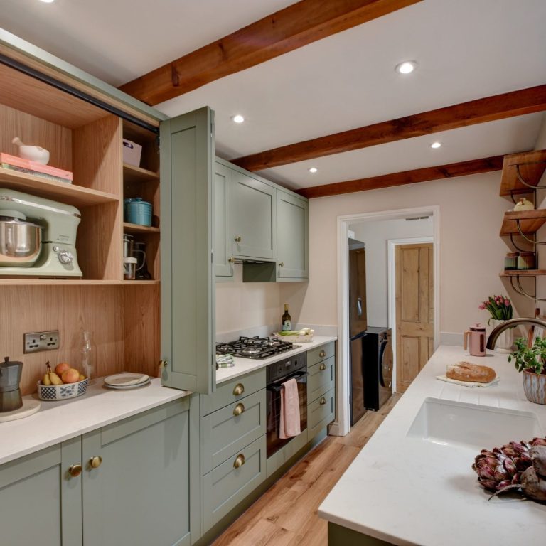 Client browsing a bespoke pantry storage wall designed by The Kitchen Room, alongside a customer testimonial from Joseph in Harrogate